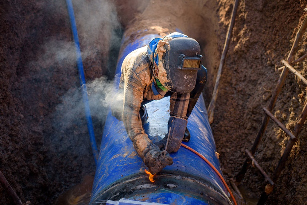 The welder is working Connecting large water pipelines in the underground
